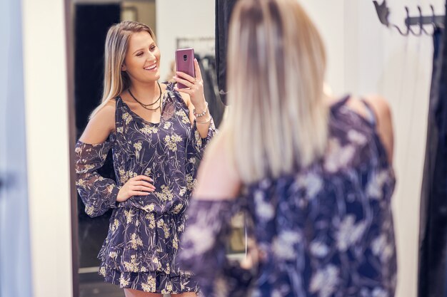 Mujer feliz comprando ropa en la tienda