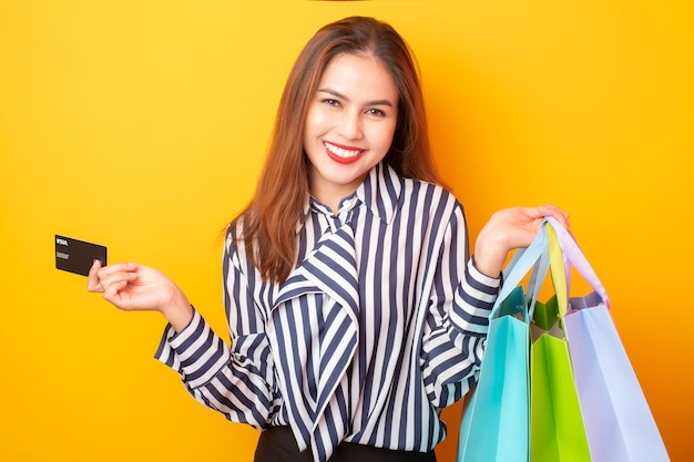 Mujer feliz de compras sobre fondo amarillo