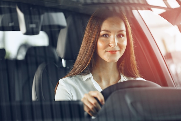 Mujer feliz conduciendo un coche y sonriendo