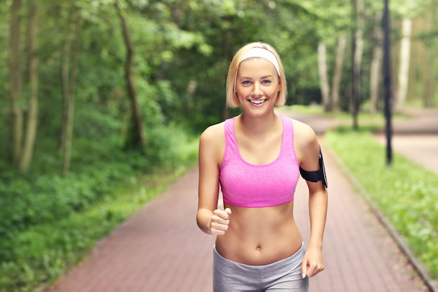 mujer feliz corriendo en el parque