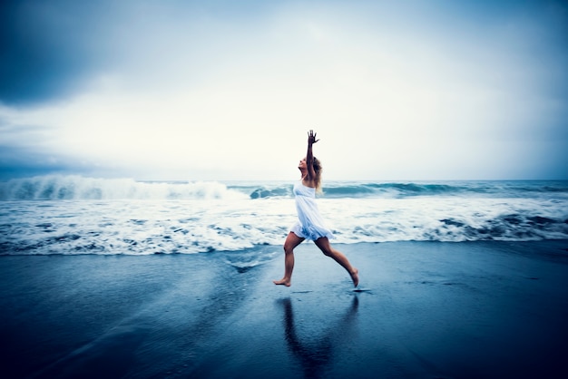 Mujer feliz corriendo en la playa