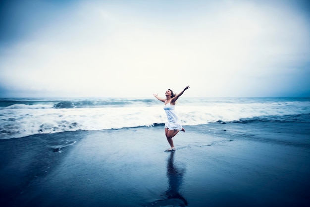 Mujer feliz corriendo en la playa