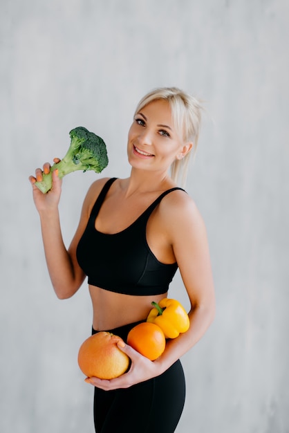 Mujer feliz delgada con frutas y verduras frescas