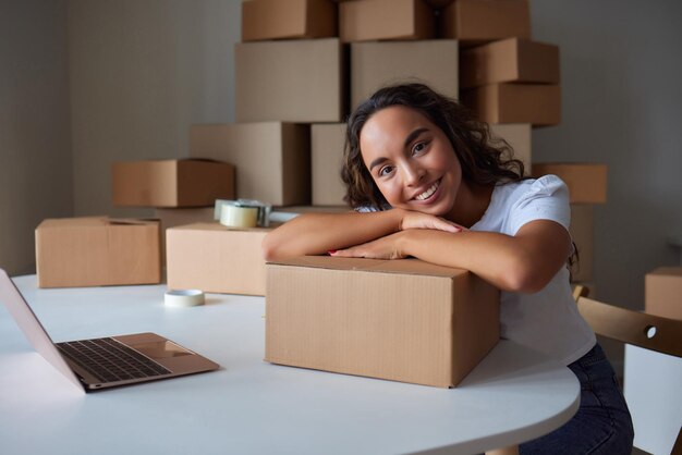 Mujer feliz desempacando el contenedor en casa abriendo la caja de cartón mirando dentro del paquete Cliente satisfecho sonriente que recibe el paquete del servicio de entrega de pedidos compra unboxing