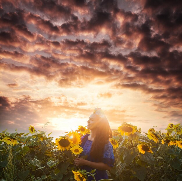 Foto mujer feliz disfruta con girasoles