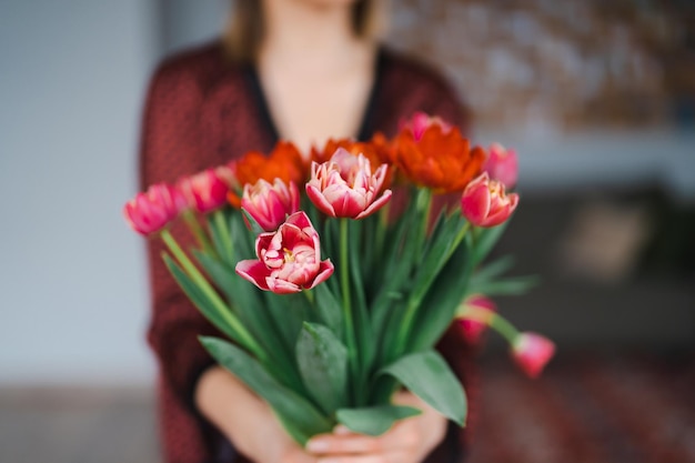 Mujer feliz disfruta de un ramo de tulipanes Ama de casa disfrutando de un ramo de flores y el interior de la cocina Dulce hogar Libre de alergias