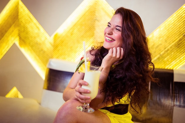 Mujer feliz disfrutando de bebidas en discoteca