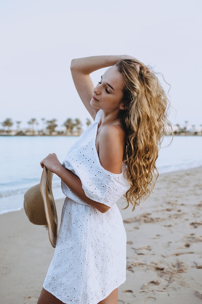 Mujer feliz disfrutando de playa relajante alegre en verano por agua azul tropical