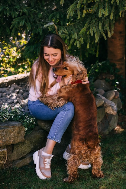 Mujer feliz disfrutando del tiempo con alegre cocker spaniel