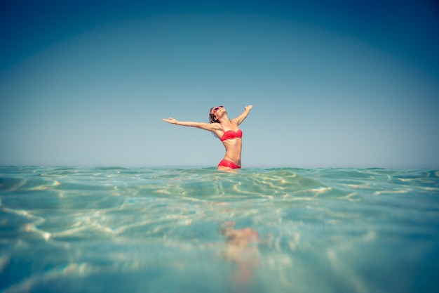 Mujer feliz divirtiéndose en el mar