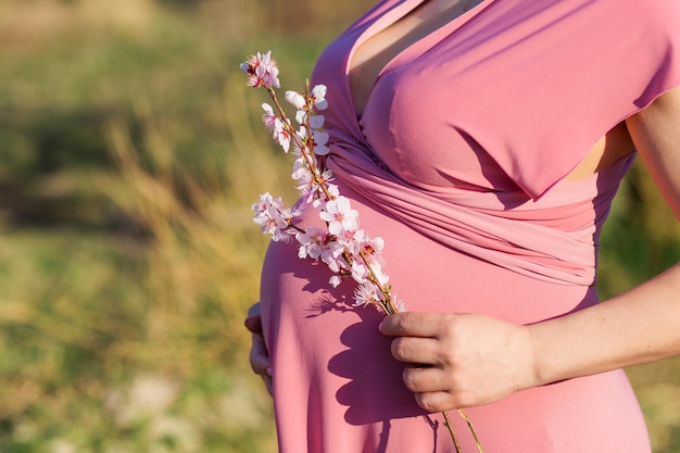 Foto mujer feliz embarazada en jardín de melocotón en flor