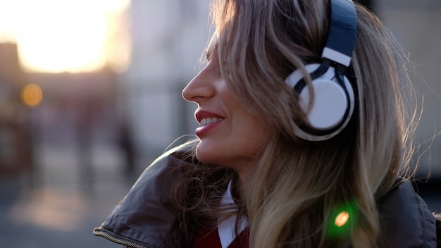 Mujer feliz escuchando música con auriculares inalámbricos