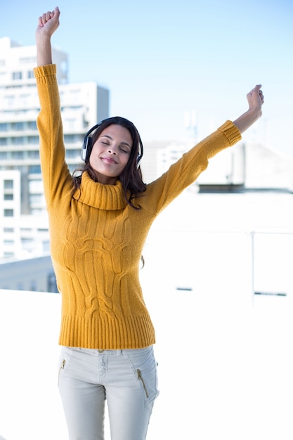 Mujer feliz escuchando música a través de auriculares