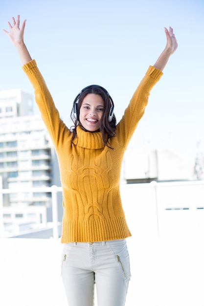 Foto mujer feliz escuchando música a través de auriculares