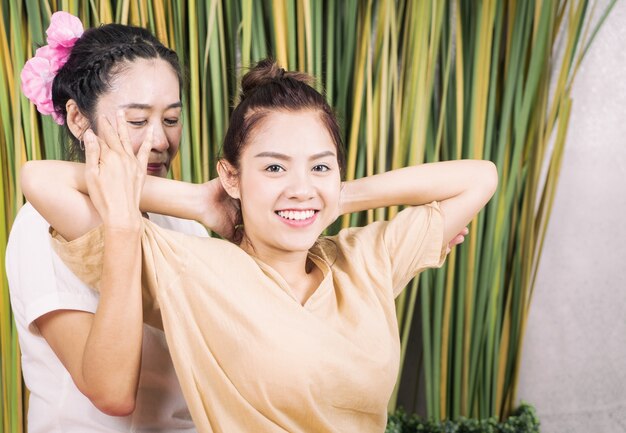 La mujer feliz está consiguiendo la posición que estira del masaje tailandés