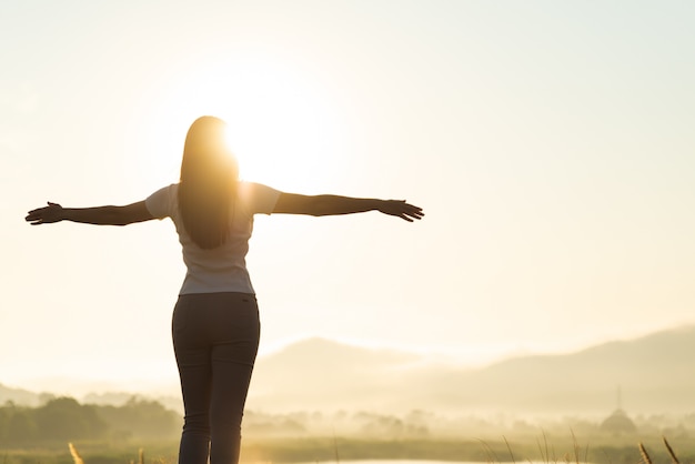 Mujer feliz extendiendo los brazos, vacaciones al aire libre libertad emociones concepto.