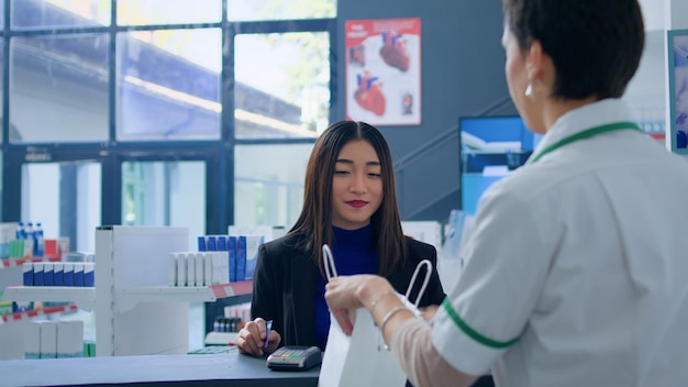 Mujer feliz en la farmacia en la caja