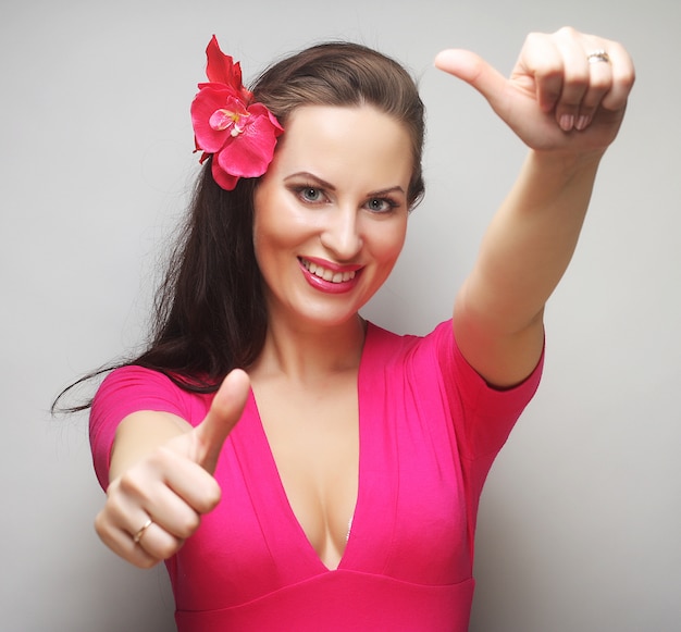 Mujer feliz con flor rosa en el pelo