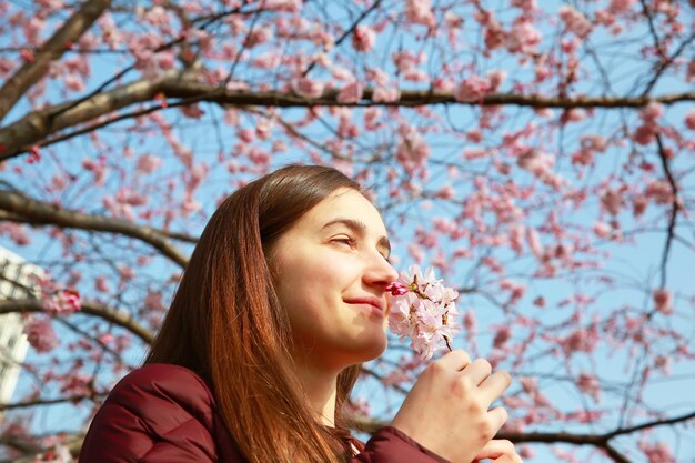 Mujer feliz con flores de cerezo