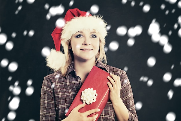 Mujer feliz con gorro de Papá Noel con caja de regalo de Navidad