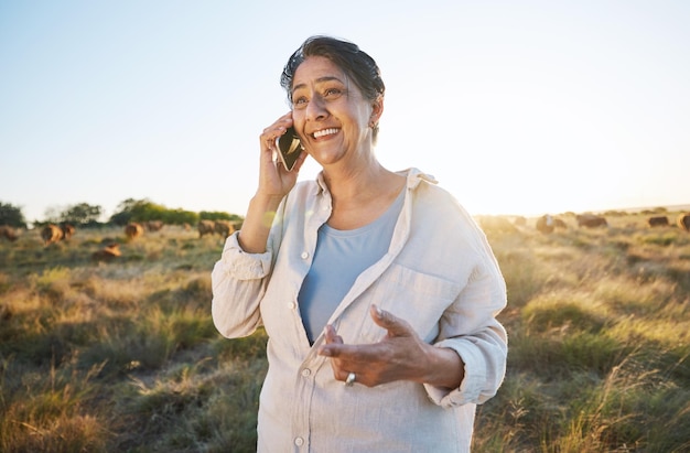 Mujer feliz y granjero con llamada telefónica en el campo por la mañana o persona en la granja con una sonrisa para conversar en la naturaleza Trabajador de ganado y conexión y comunicación de redes sociales rurales