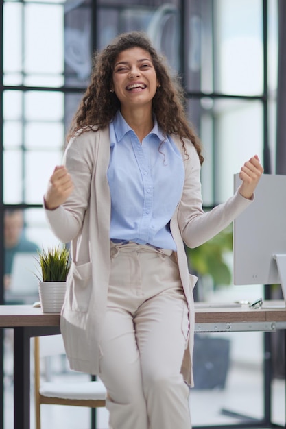 Foto la mujer feliz grita haciendo un gesto ganador con los puños apretados