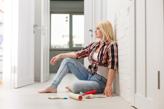 mujer feliz hace reparaciones en la habitación en casa