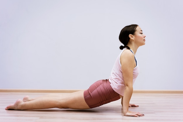 Mujer feliz haciendo deporte en casa contra la pared de la pared, concepto de estilo de vida saludable