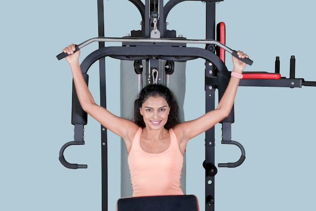 Mujer feliz haciendo un entrenamiento con una máquina de fitness