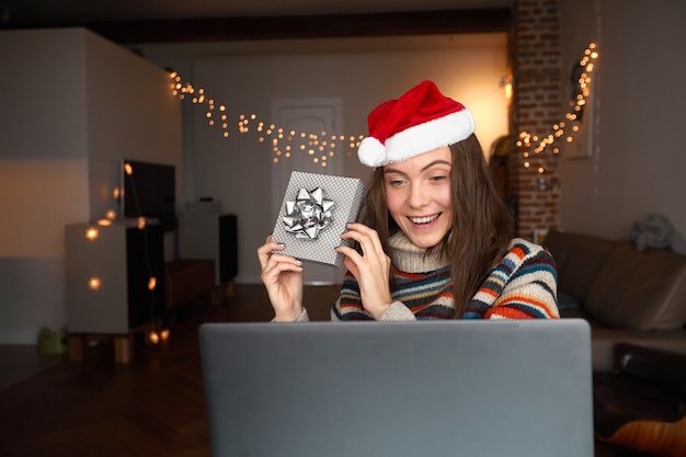 Foto mujer feliz haciendo videollamadas durante la celebración de navidad