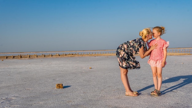 Mujer feliz con un hermoso vestido joven en el fondo de un lago blanco de sal con