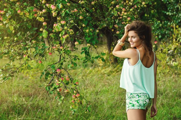 Mujer feliz en el jardín durante una cosecha de manzanas