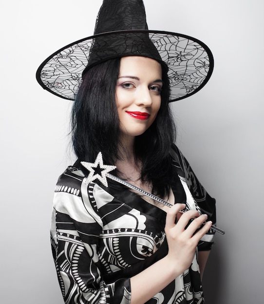 Mujer feliz joven bruja divertida con sombrero canival Foto de estudio