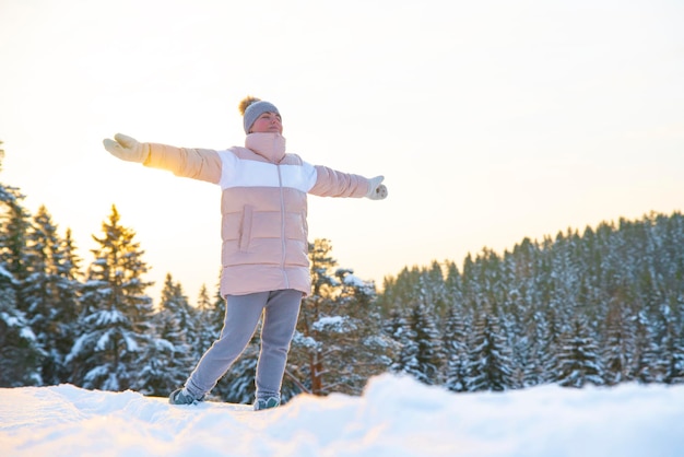 Foto mujer feliz, joven, relajado, despreocupado, hombre libre, respira aire fresco y profundo al aire libre en un frío invierno cubierto de nieve