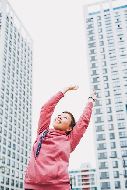 Foto mujer feliz joven entre skyscapers en la ciudad salud física y mental