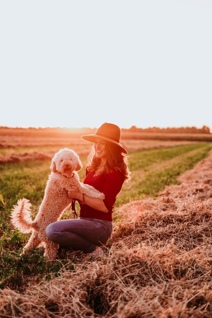 Foto mujer feliz jugando con el perro en la granja