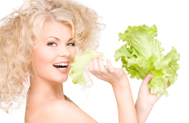 Mujer feliz con lechuga sobre pared blanca