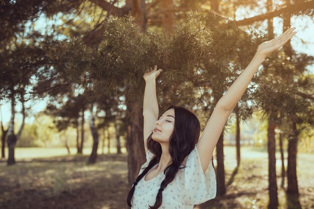 Mujer feliz libre en el bosque disfrutando de la naturaleza Chica de belleza natural al aire libre en concepto de disfrute de libertad