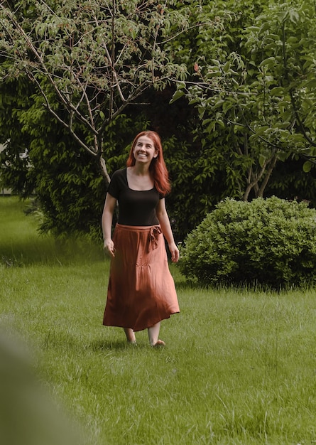 Mujer feliz libre de mediana edad caminando descalzo en el parque