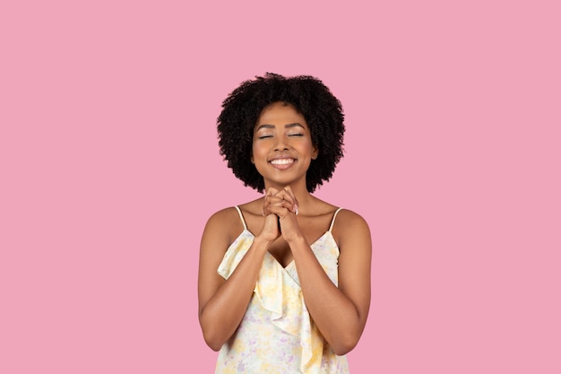 Mujer feliz con las manos juntas en rosa