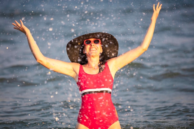 Mujer feliz en el mar bajo el sol