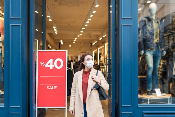 Foto mujer feliz con máscara de pie junto al centro comercial