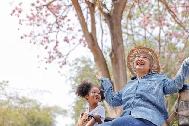 Foto mujer feliz mirando lejos contra los árboles