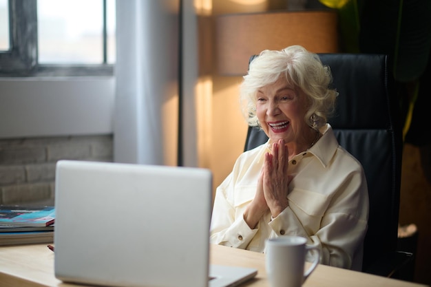 Mujer feliz mirando la pantalla del portátil