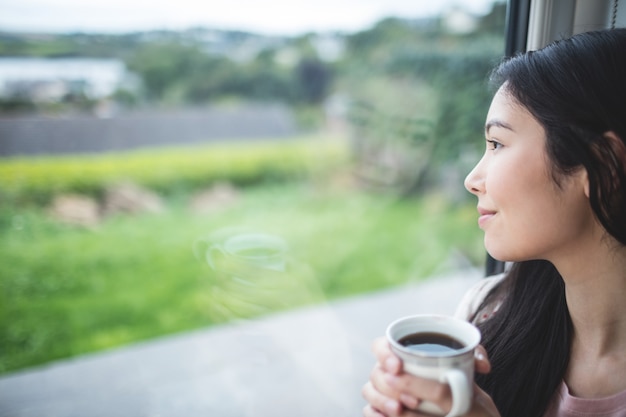 Mujer feliz mirando por la ventana