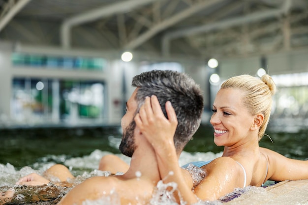 Mujer feliz mostrando amor Spa y amor Pareja en el centro de spa en la piscina