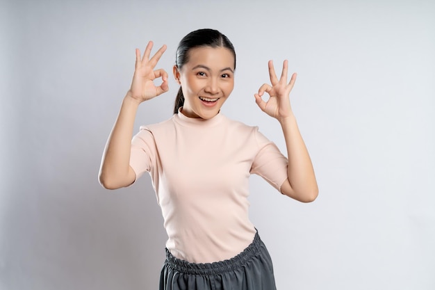 Mujer feliz mostrando gesto OK aislado sobre fondo