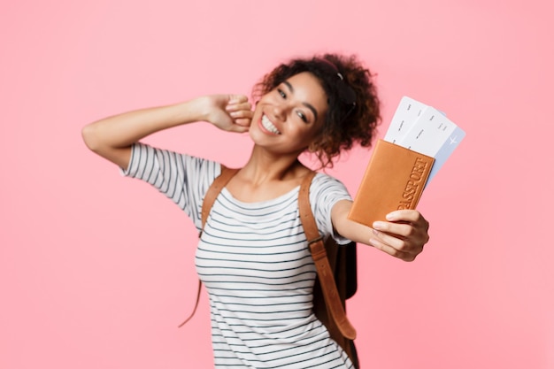 Foto mujer feliz mostrando pasaporte y boletos sobre antecedentes