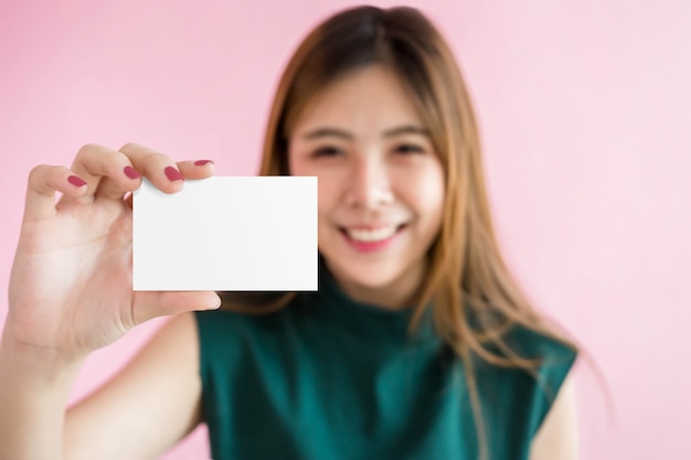 Mujer feliz muestra una tarjeta en blanco para maqueta, trazado de recorte incluido