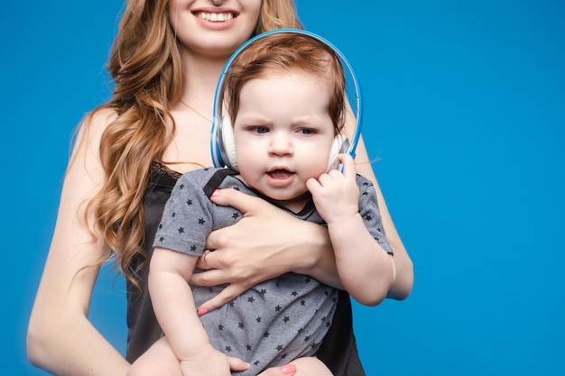 Mujer feliz con niño en auriculares.